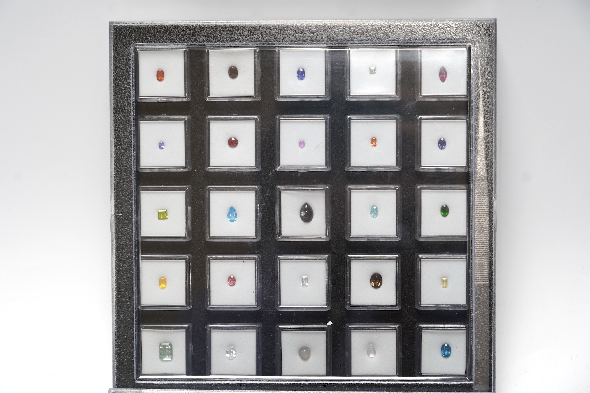 Three boxes containing unmounted cut gemstones including topaz, citrine, peridot, zircon, moonstone, etc. Condition - fair